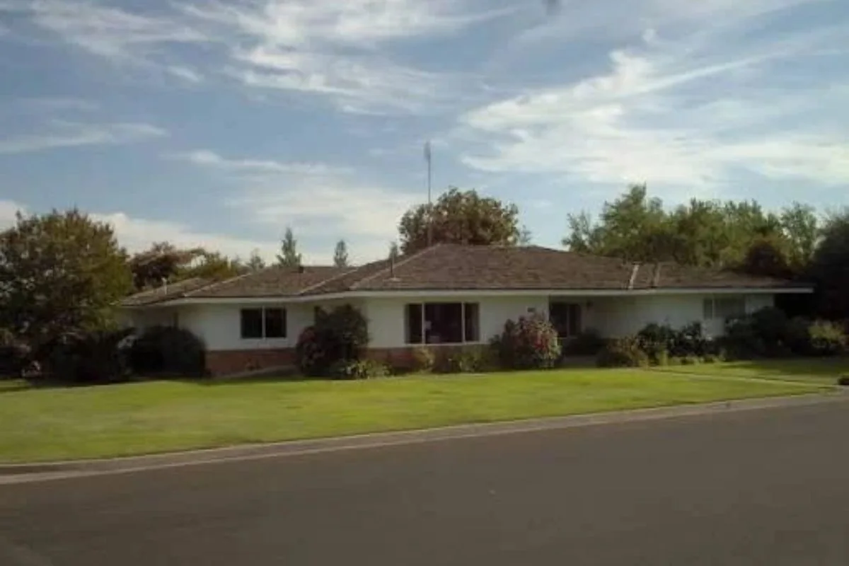 Ranch-style house with a green lawn on a quiet street