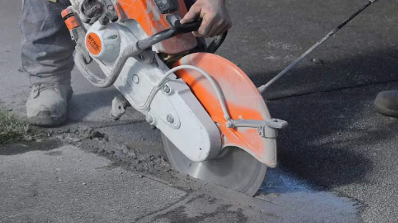 Technician cutting into concrete with a handheld saw