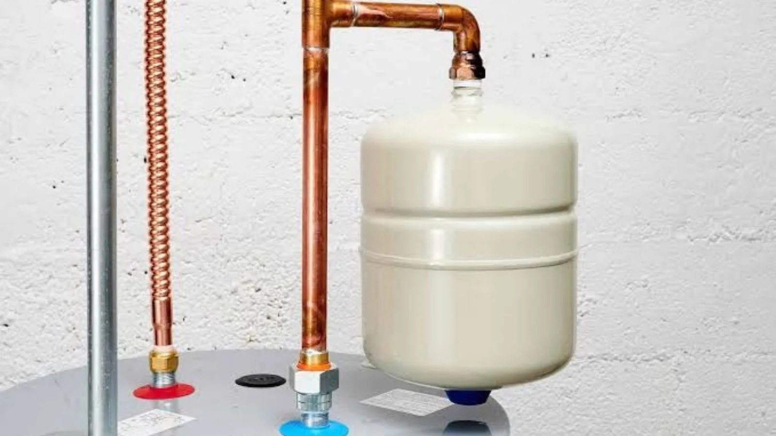 Expansion tank mounted on top of a water heater with copper supply lines