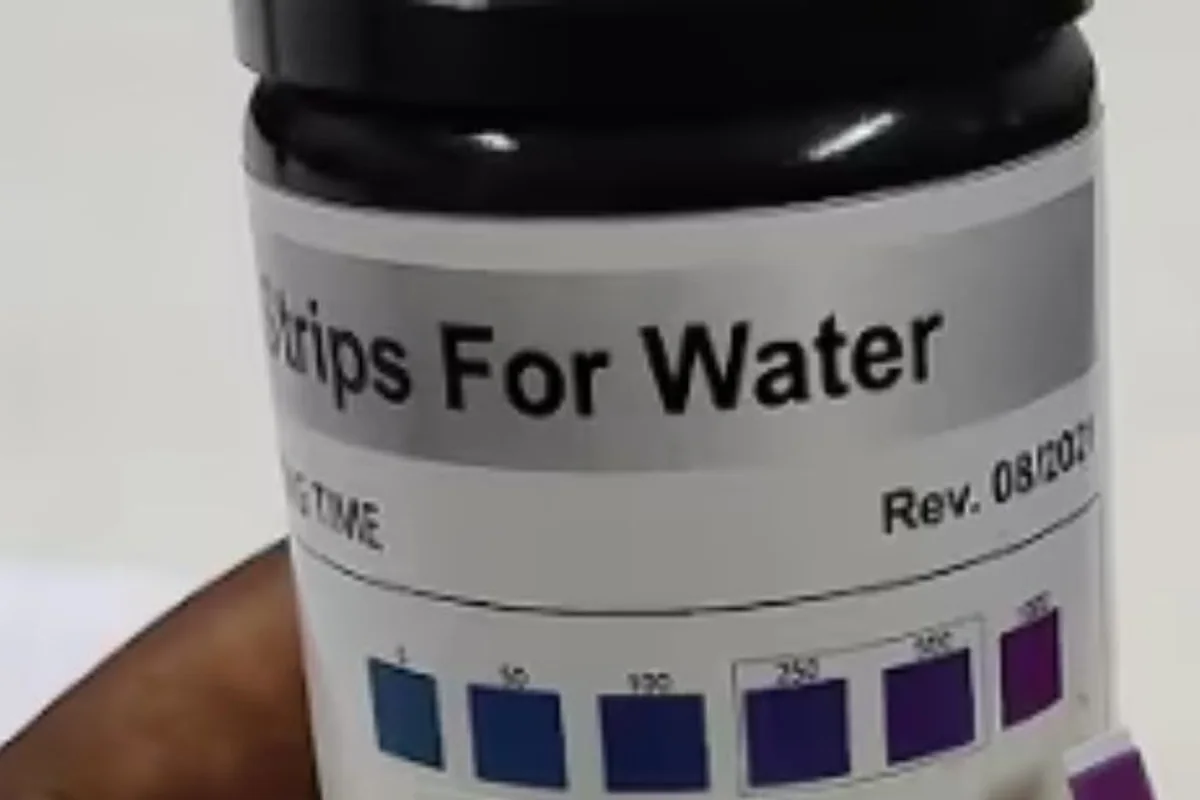 Close-up of a vial of water test strips with its color chart